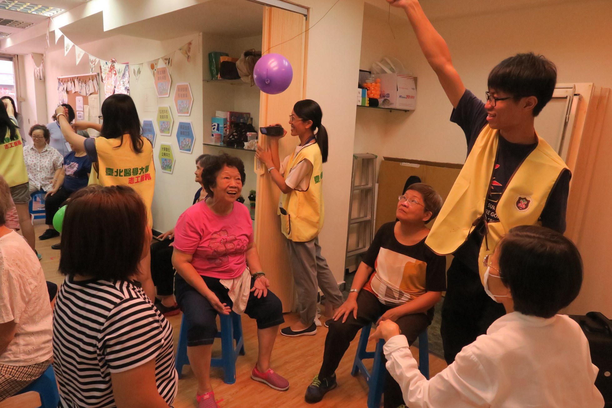 學生於展齡中心，協助課程，展現活潑面容