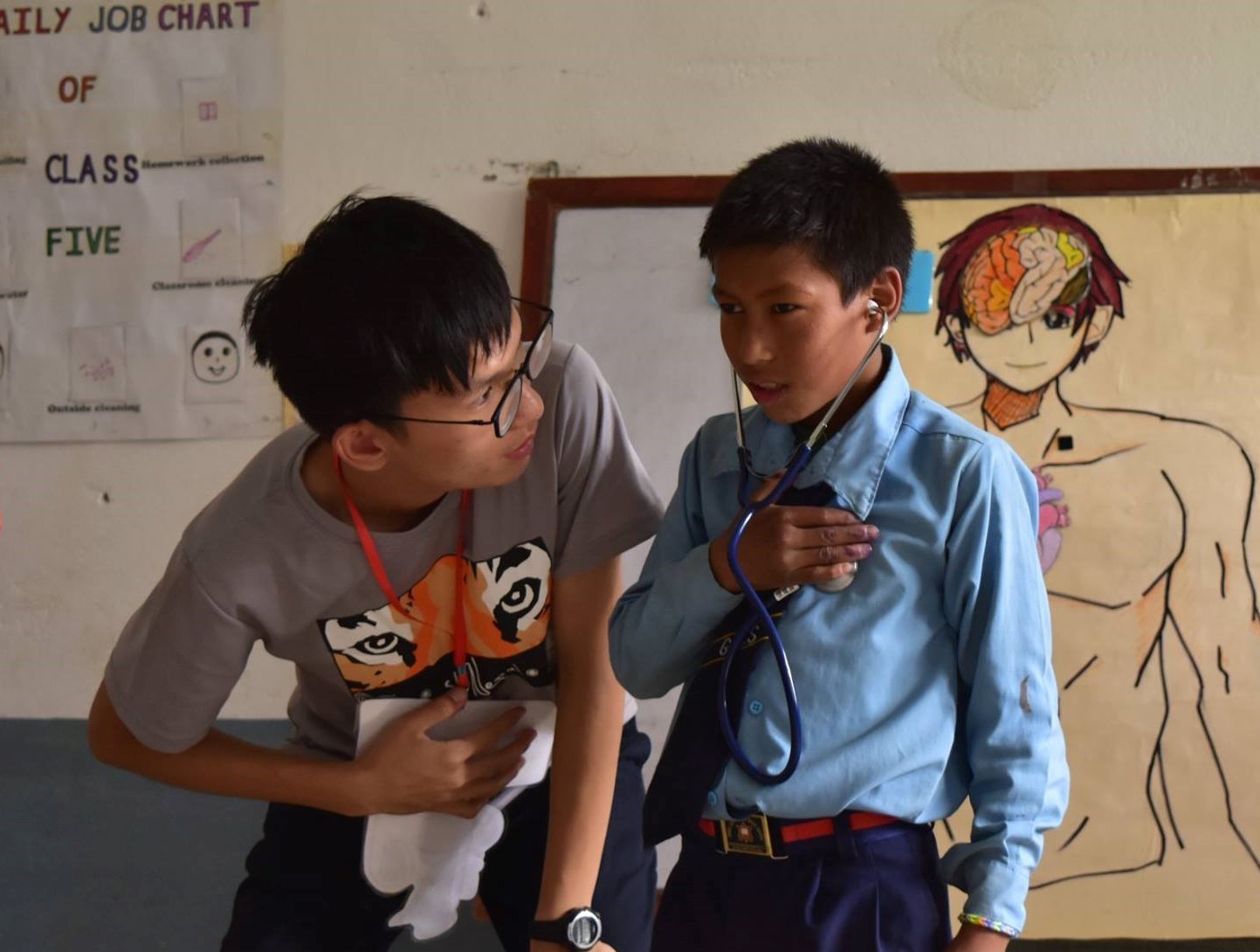 國防(尼泊爾)團員謝士博正在進行衛教課程，讓學童聽自己的心跳聲，協助認識身體器官。.jpg