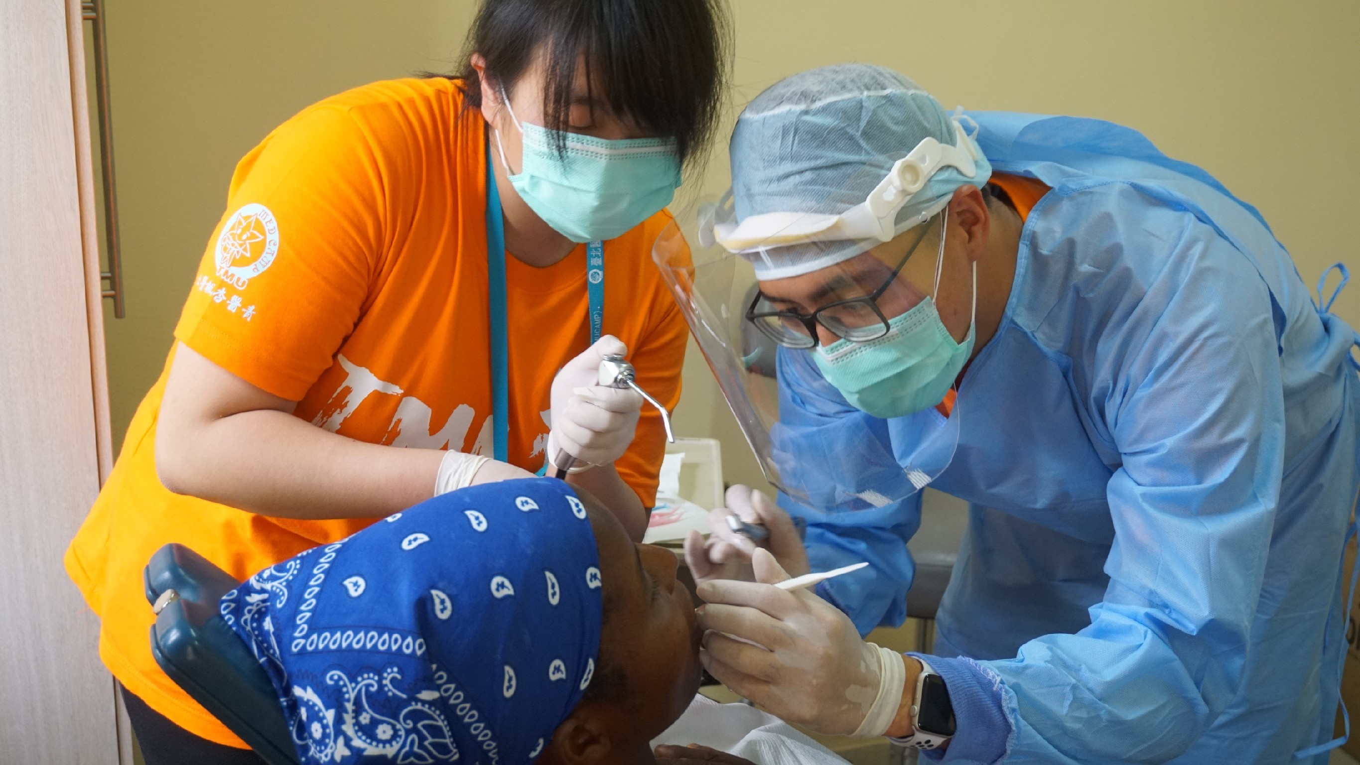 照片1-團員與牙醫師正協助為當地孩童進行口腔治療。