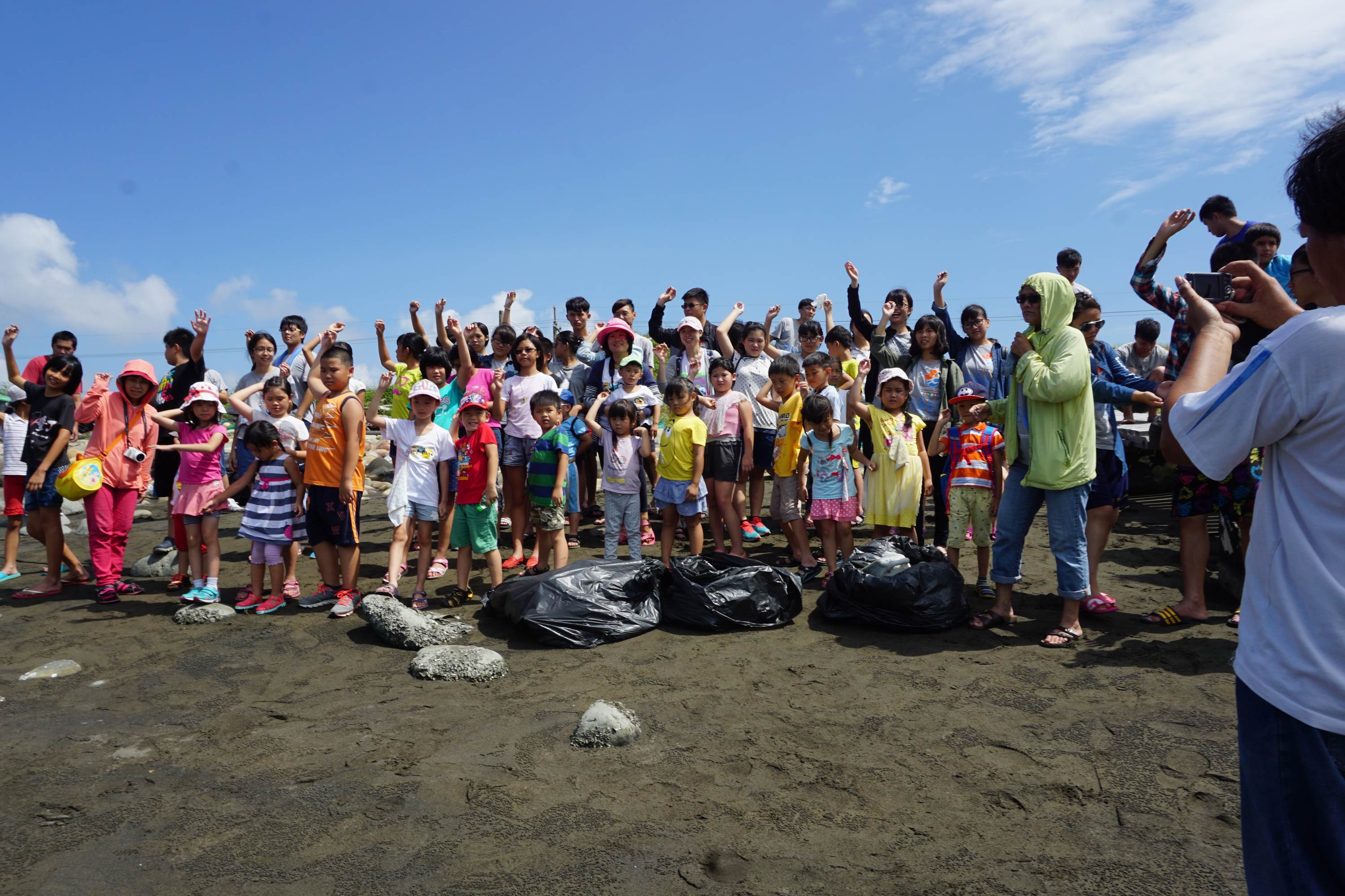 志工帶著孩童進行淨灘活動