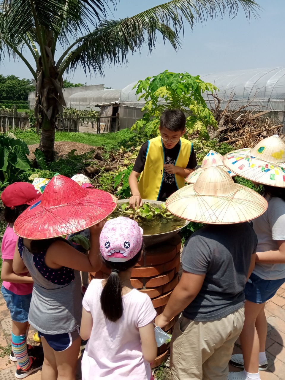魏智瀚同學（黃色背心）向小朋友介紹生態池