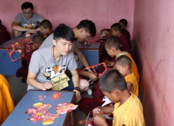 照片一:國防醫學院享尼尼泊爾國際志工團團員在佛學院進行元宵節慶課程,教導孩童製作燈籠。.png