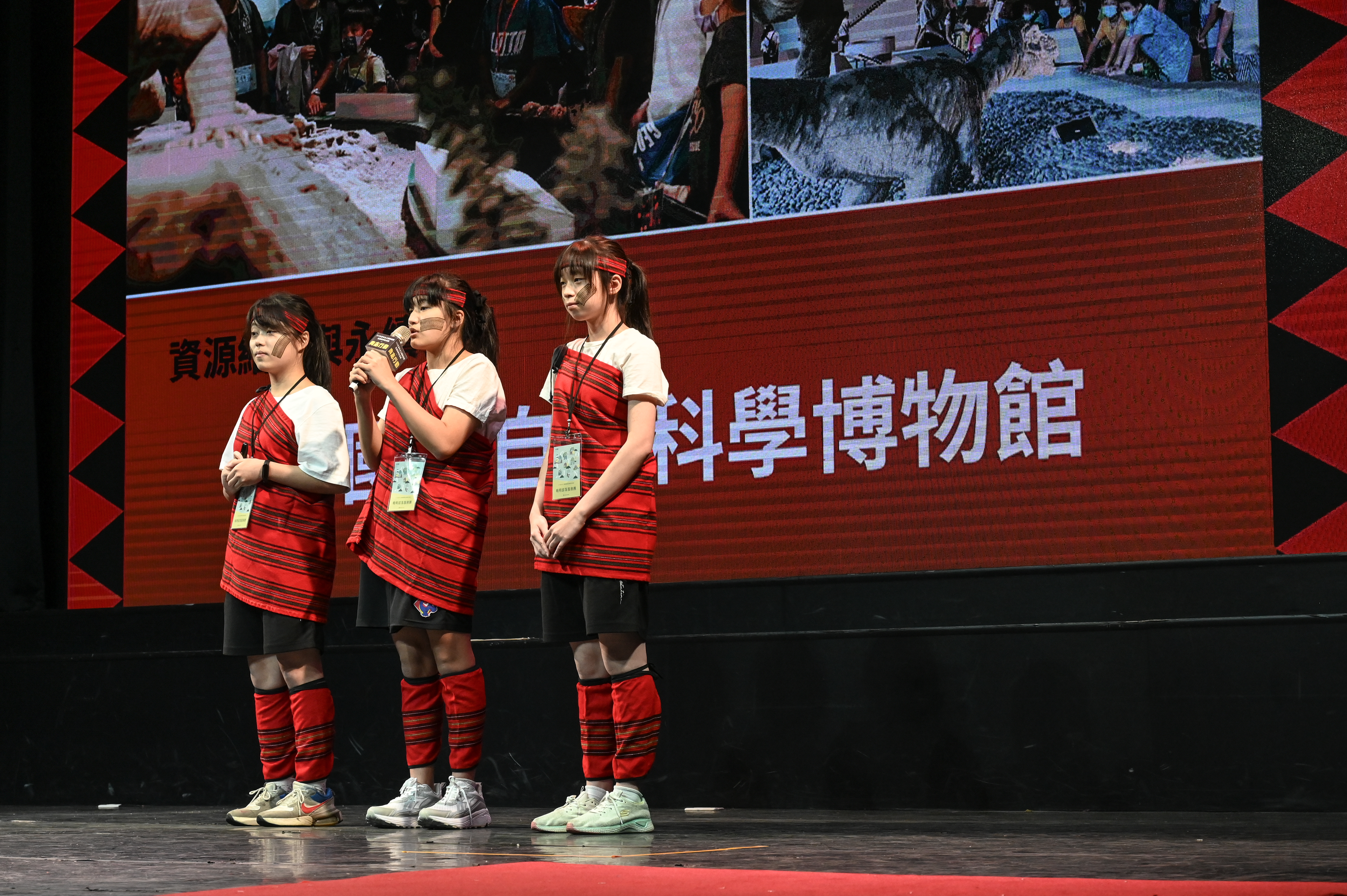 團隊穿著部落服飾進行簡報(曉明部落服務團)