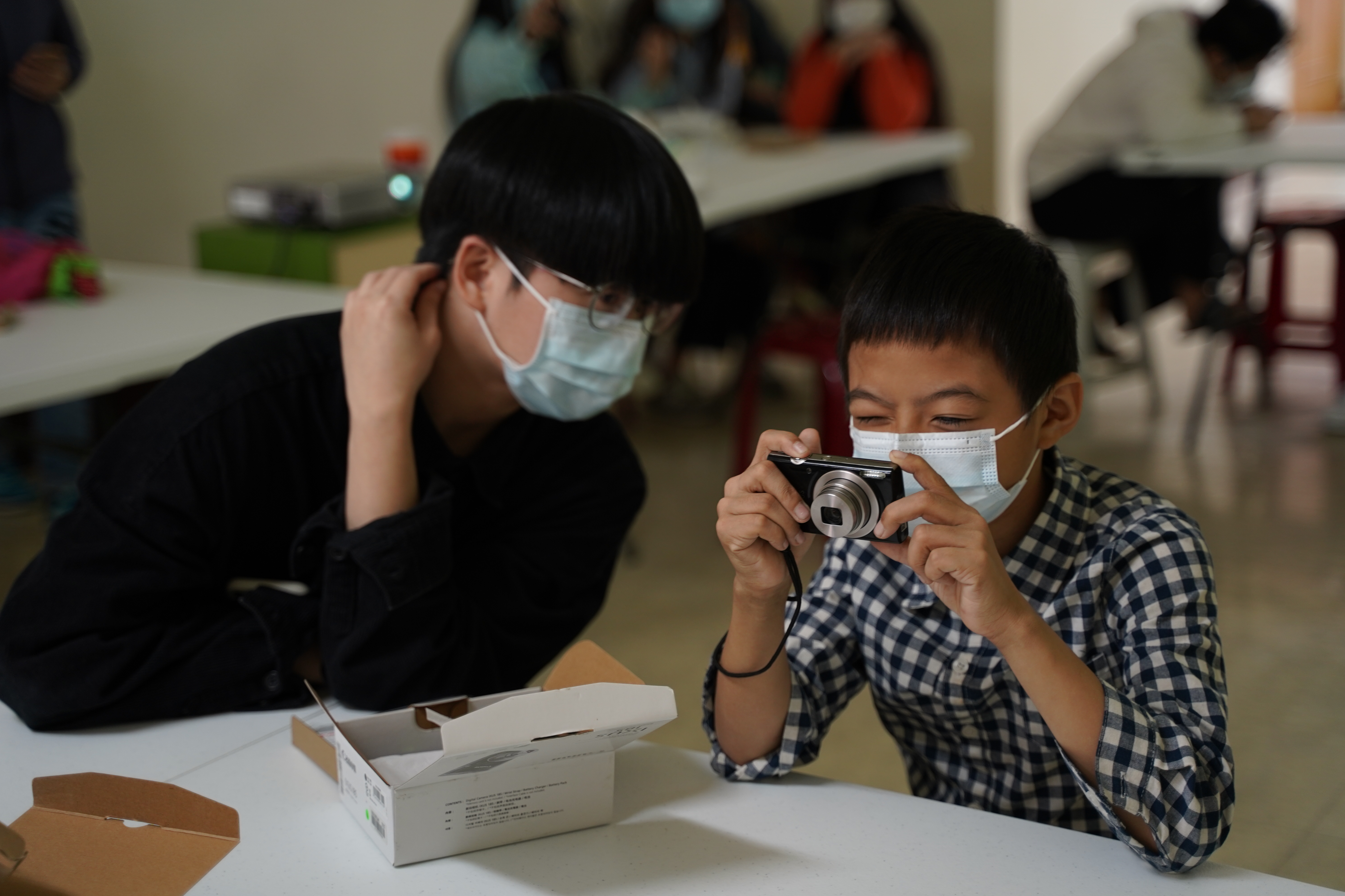 攝影志工陪伴孩子一起學習基礎相機使用規則(社團法人臺灣兒少玩心教育協會提供)