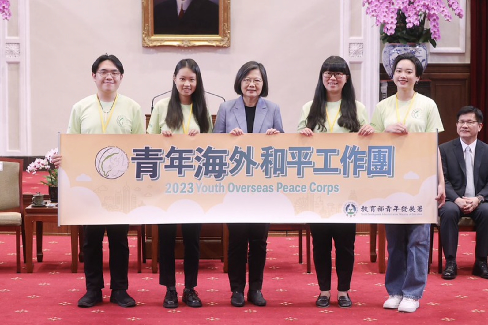 蔡總統和四位青年志工代表（左至右：袁泰智、李盈萱、林語珊、黃馨平）授旗後合影